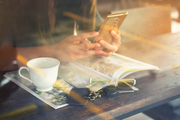 Mulher jovem, segurando, smartphone, em, a, barra café