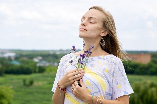 Mulher jovem segurando um buquê de lavanda