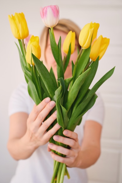 Mulher jovem segurando um buquê de tulipas festivas de primavera nas mãos