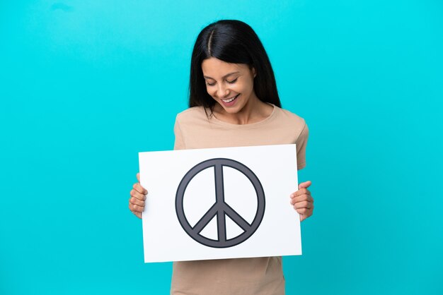 Mulher jovem segurando um cartaz com o símbolo da paz em um fundo isolado