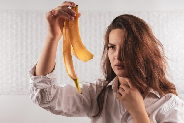 Foto mulher jovem segurando uma casca de banana