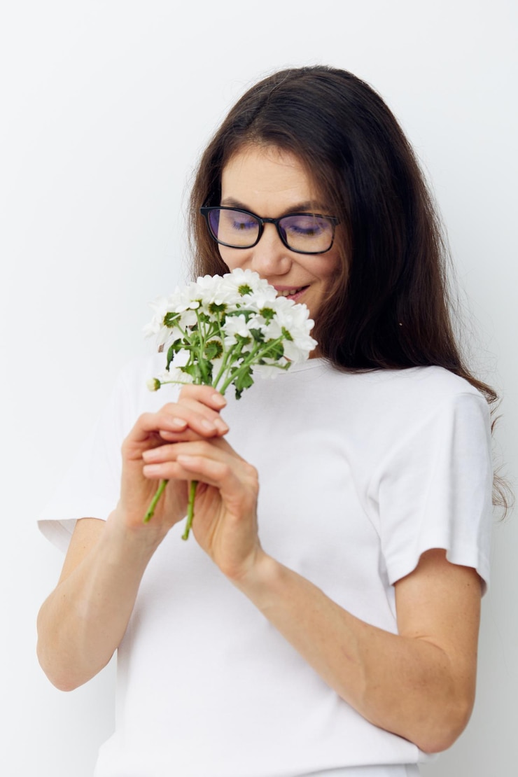 Foto mulher jovem segurando uma flor contra um fundo branco