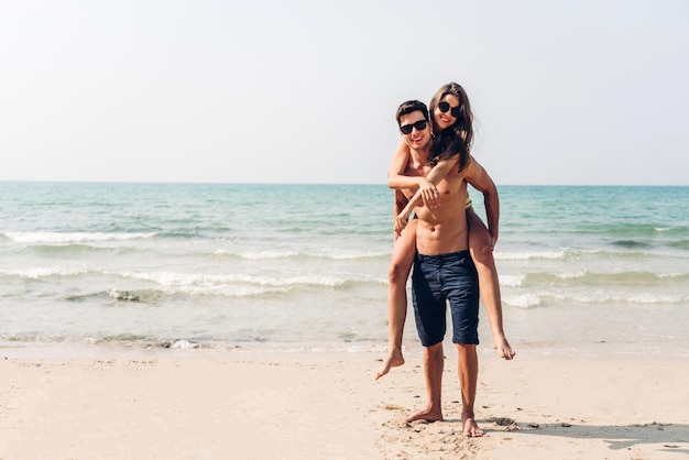 Foto mulher jovem sem camisa de pé na praia