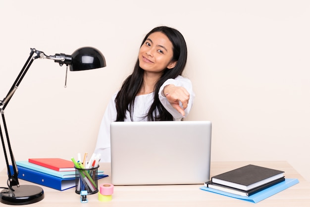 Mulher jovem sentada à mesa com um laptop