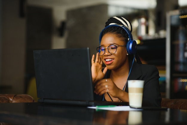 Mulher jovem sentada em um café trabalhando em um laptop