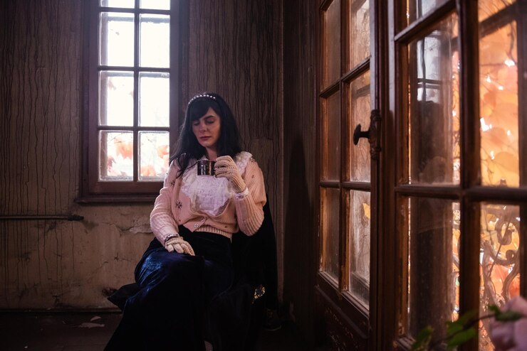 Foto mulher jovem sentada na janela em casa