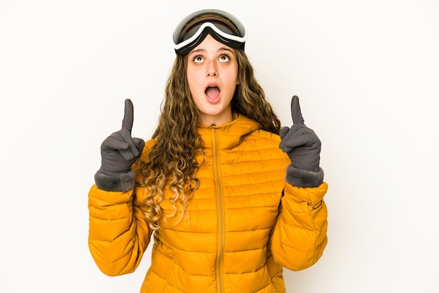 Mulher jovem snowboarder caucasiana isolada apontando para cima com a boca aberta.