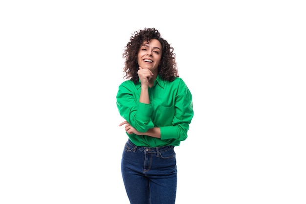 Mulher jovem sorridente com cabelos encaracolados pretos vestida com uma blusa verde