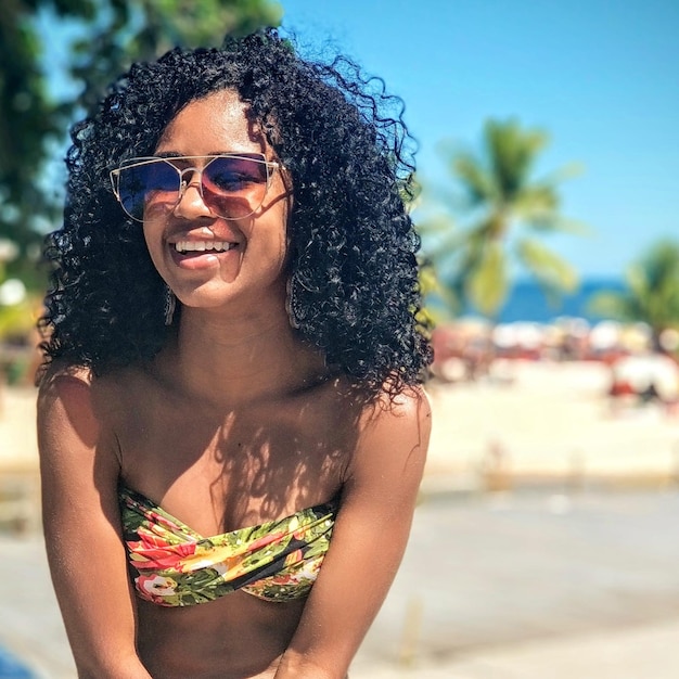 Mulher jovem sorridente com óculos de sol