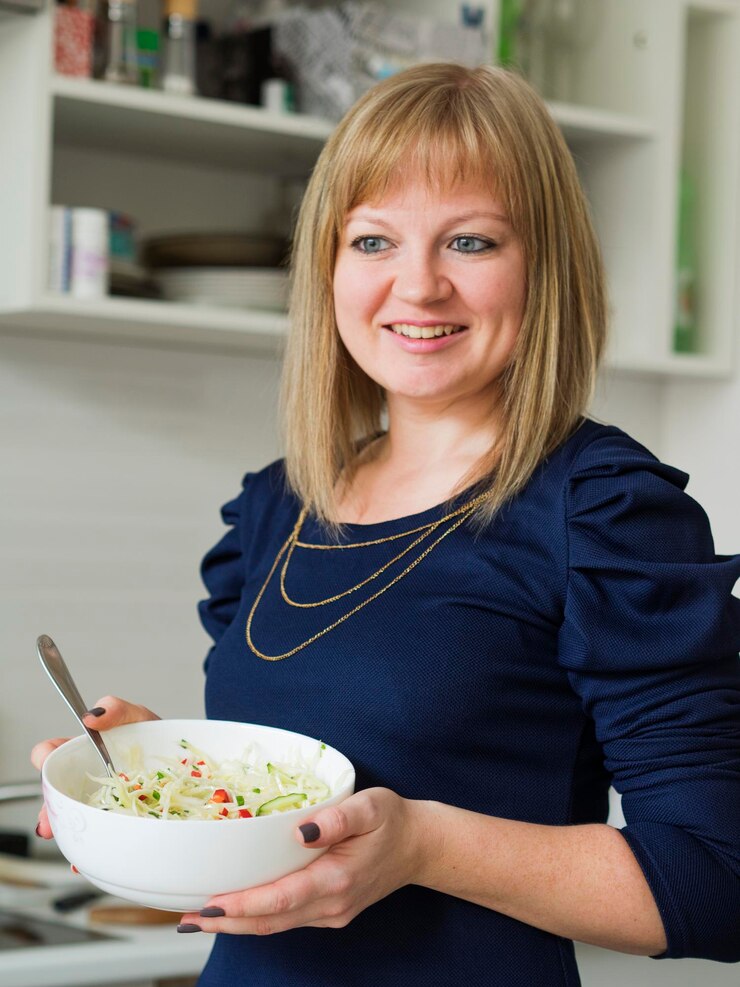 Foto mulher jovem sorridente com salada em casa