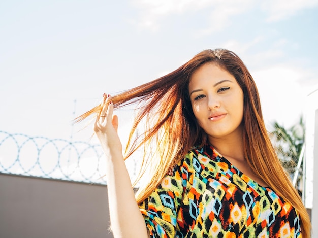 Mulher jovem sorridente contra o céu