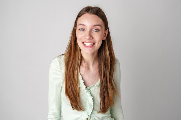 Mulher jovem sorridente contra um fundo branco no estúdio