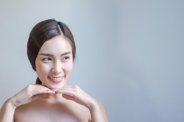 Mulher jovem sorridente contra um fundo cinzento