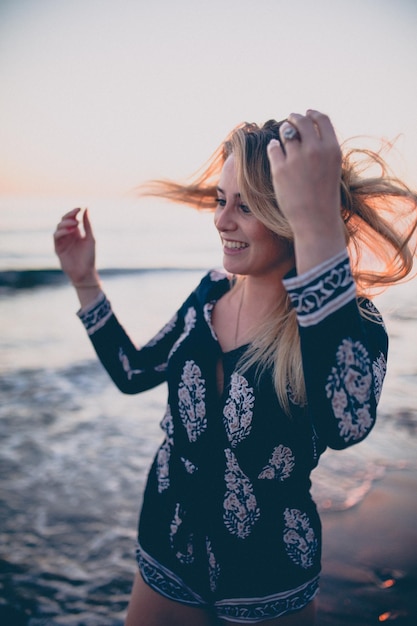 Mulher jovem sorridente de pé na praia