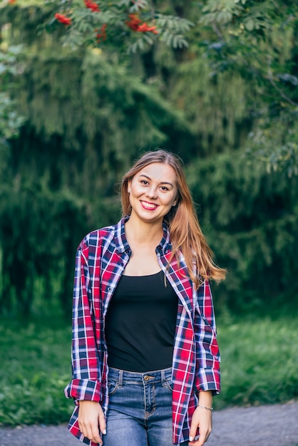 Mulher jovem sorridente em pé no parque