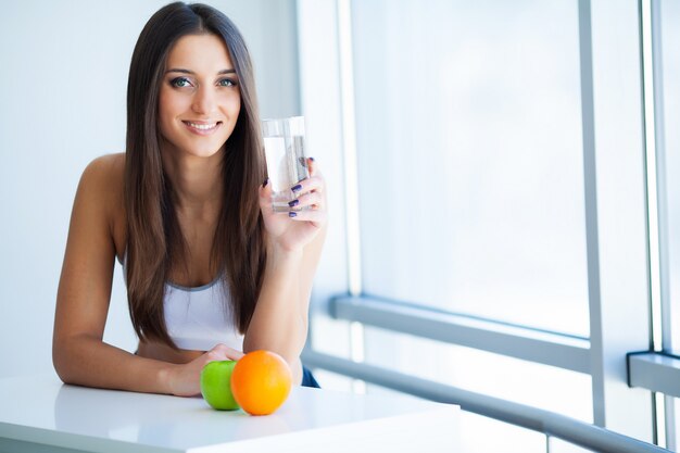 Mulher jovem sorridente feliz tomando suplemento dietético