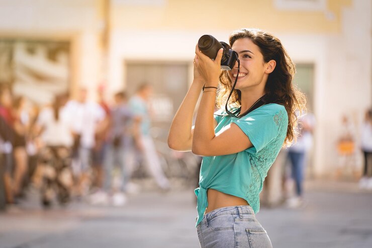 Foto mulher jovem sorridente fotografando na cidade