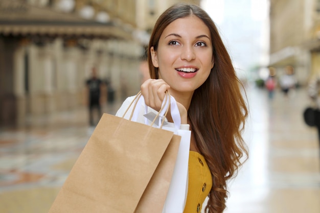 Mulher jovem sorridente moda segurando sacolas de compras