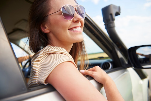 Mulher jovem sorridente olhando a vista durante a viagem