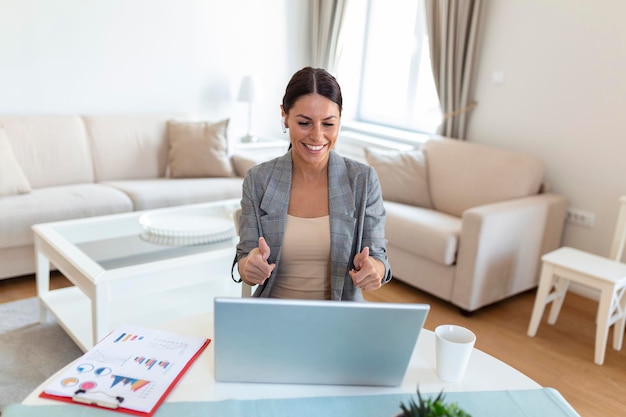 Mulher jovem sorridente usando laptop em casa olhando para a tela conversando usando fone de ouvido sem fio tendo instrutor de negócios de videoconferência tutoria pelo conceito de ecoaching de treinamento on-line de webcam