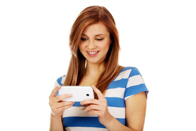 Foto mulher jovem sorridente usando telefone contra um fundo branco
