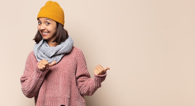 Foto mulher jovem sorrindo com uma atitude positiva, bem-sucedida e feliz apontando, fazendo sinal de arma com as mãos