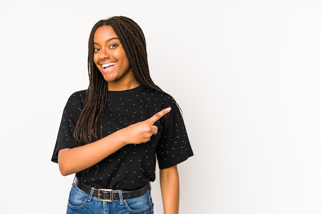 Mulher jovem sorrindo e apontando para o lado, mostrando algo