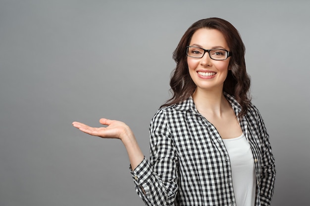 Mulher jovem sorrindo e gesticulando para copiar o espaço