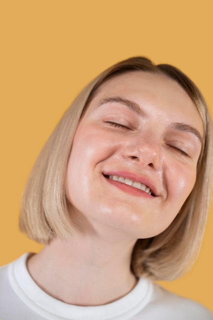 Mulher jovem sorrindo isolada em amarelo