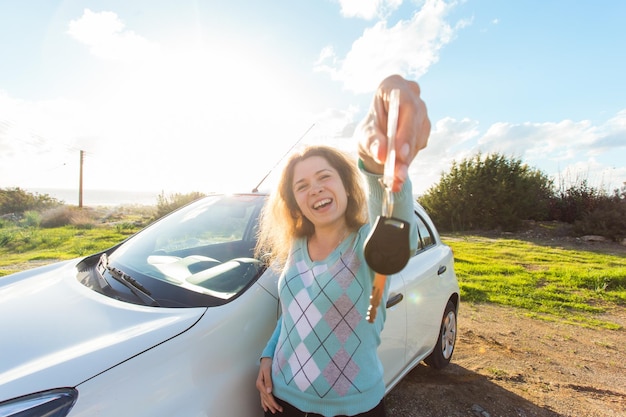 Foto mulher jovem sorrindo no carro contra o céu