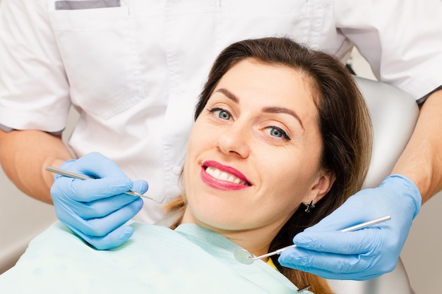 Mulher jovem sorrindo para a consulta no dentista.