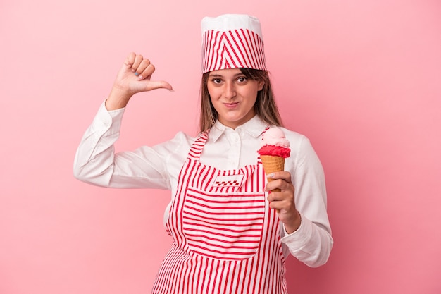 Mulher jovem sorveteira segurando sorvete isolado no fundo rosa se sente orgulhosa e autoconfiante, exemplo a seguir.