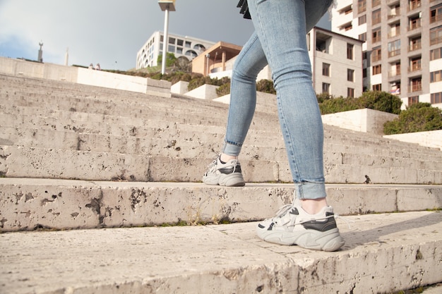 Mulher jovem subindo as escadas na cidade.