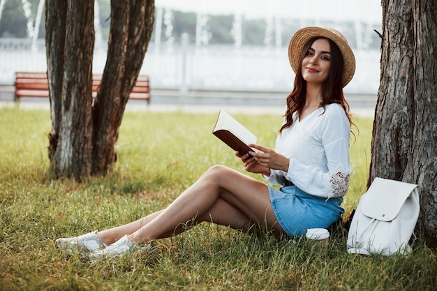 Mulher jovem tem fim de semana e fica sentada no parque durante o dia