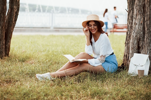 Mulher jovem tem fim de semana e fica sentada no parque durante o dia