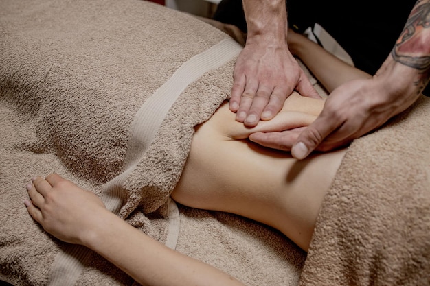 Mulher jovem, tendo a massagem do abdômen. massagista faz massagem para estômago.