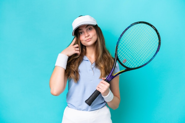 Mulher jovem tenista isolada em um fundo azul, pensando em uma ideia