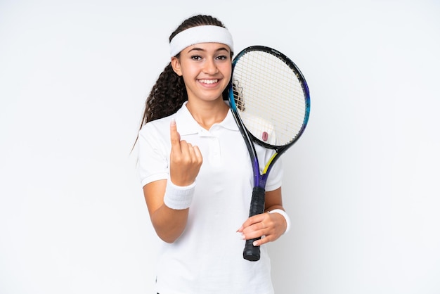 Mulher jovem tenista isolada no fundo branco, fazendo o gesto de chegada