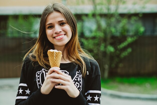 Mulher jovem tomando sorvete em um dia ensolarado ao ar livre