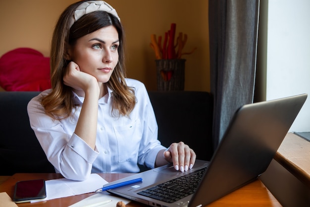 Mulher jovem trabalhando no computador em um café