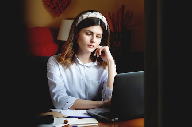 Mulher jovem trabalhando no computador em um café