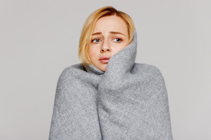 Foto mulher jovem triste olhando para longe enquanto usa um xale contra um fundo branco