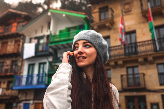 Mulher jovem turista caucasiana usando o smartphone em uma cidade velha.