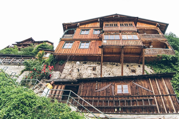 Mulher jovem turista muito sorridente andando por pequenas escadas de rua hallstatt. férias de verão