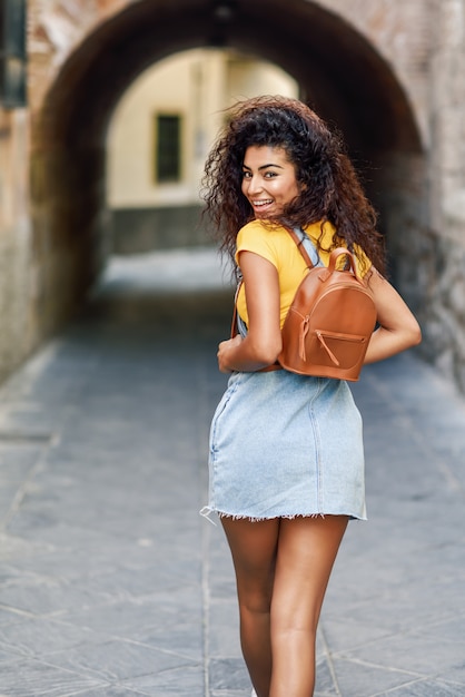 Mulher jovem turista negro com penteado encaracolado ao ar livre