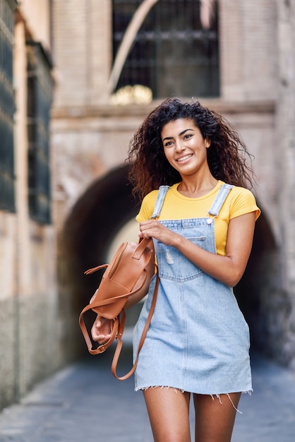 Mulher jovem turista negro com penteado encaracolado ao ar livre