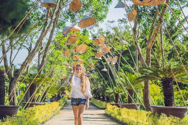 Mulher jovem turística e chapéus vietnamitas viajam pelo conceito do Vietnã