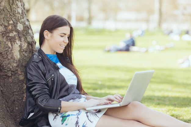 Mulher jovem, usando computador, em, parque, em, londres