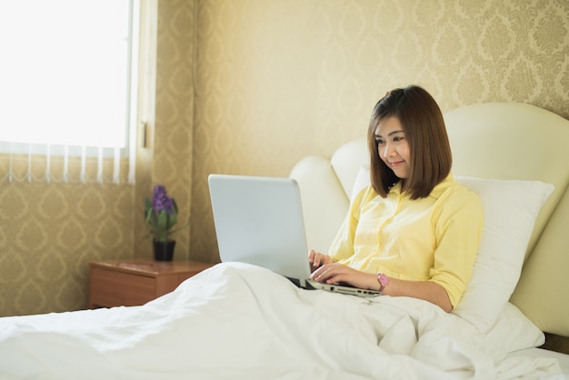 Mulher jovem, usando computador portátil, em, quarto, casa