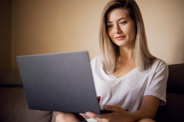 Mulher jovem usando laptop em casa